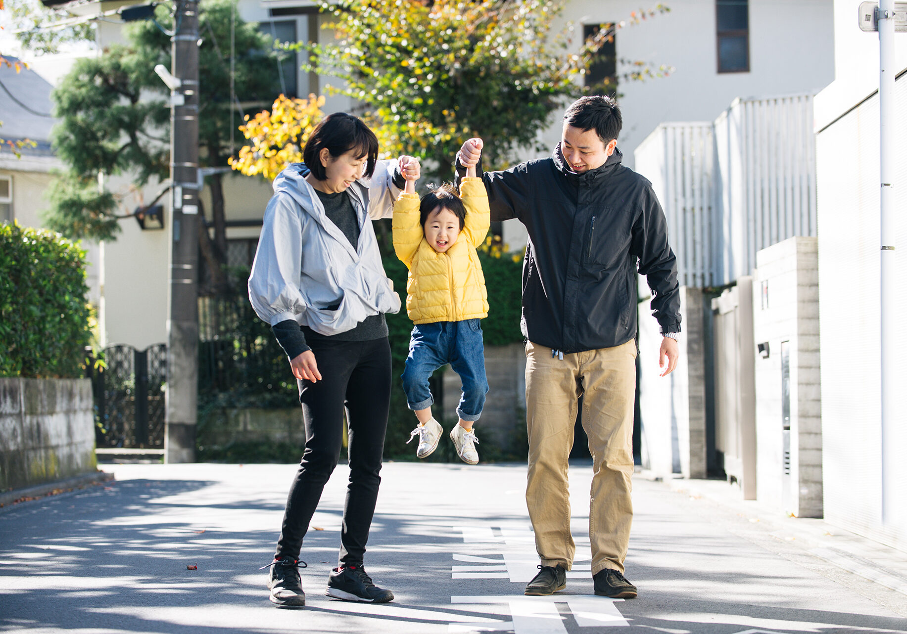 Happy and playful japanese family with small cute daughter having fun outdoors